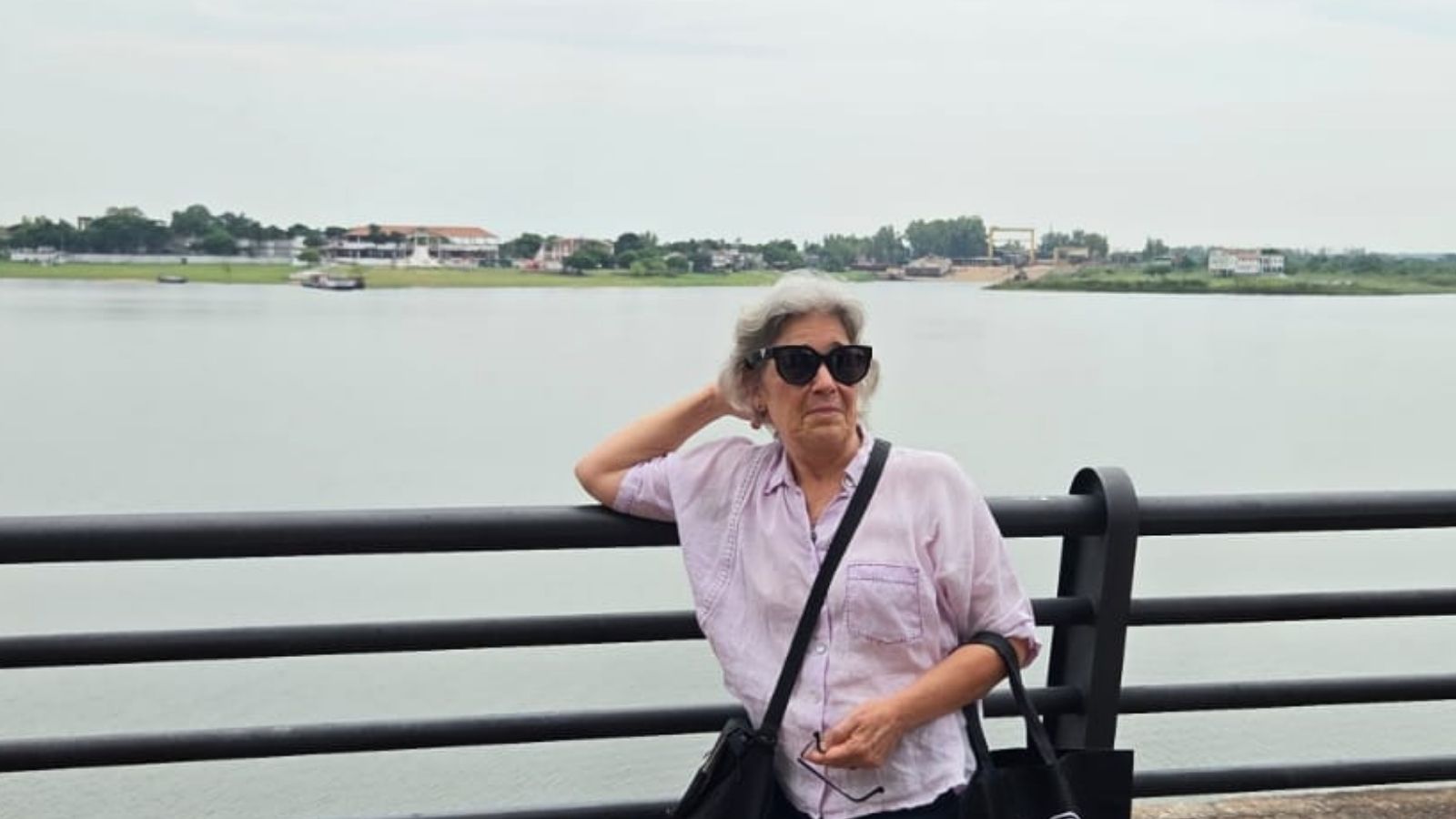 Woman standing by a riverside railing in Paraguay