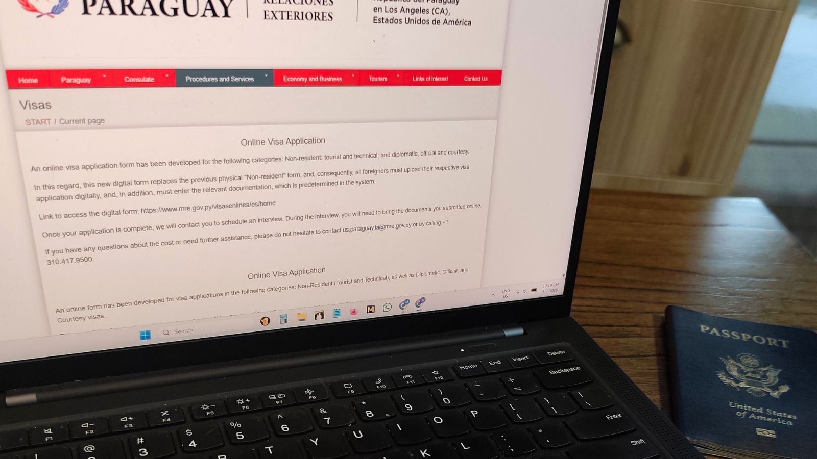 Applying for a visa online with passport and laptop